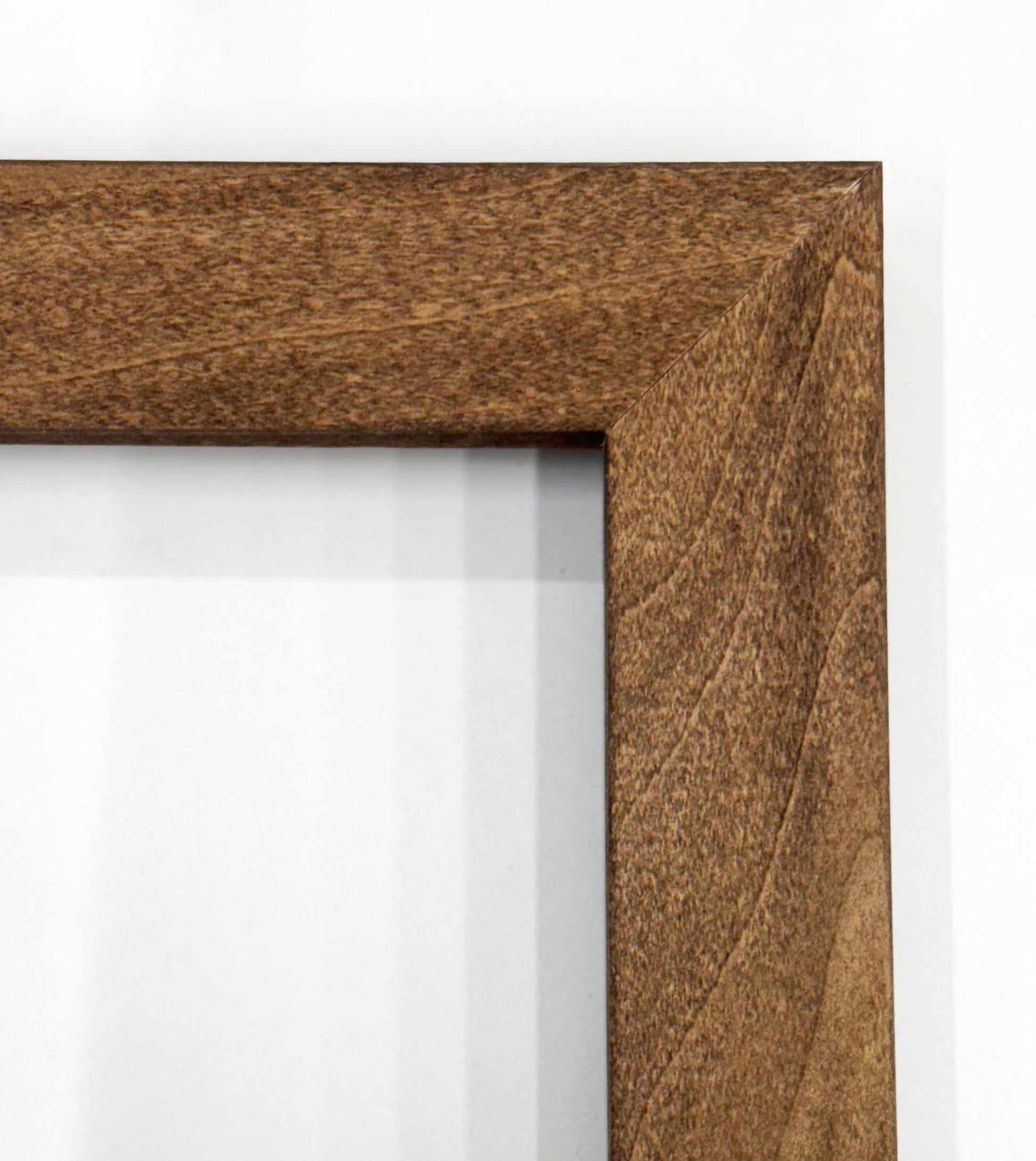 a close-up view of a wooden frame with a textured, dark brown finish.