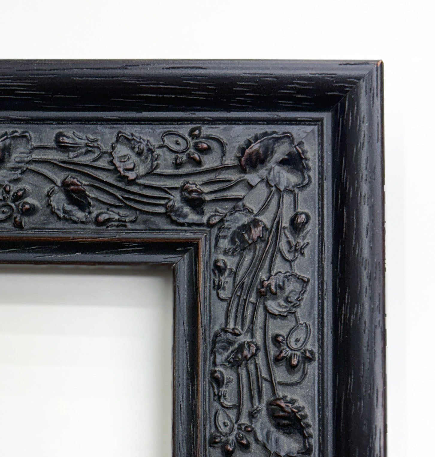 a black ornate frame with intricate floral designs on the edges.