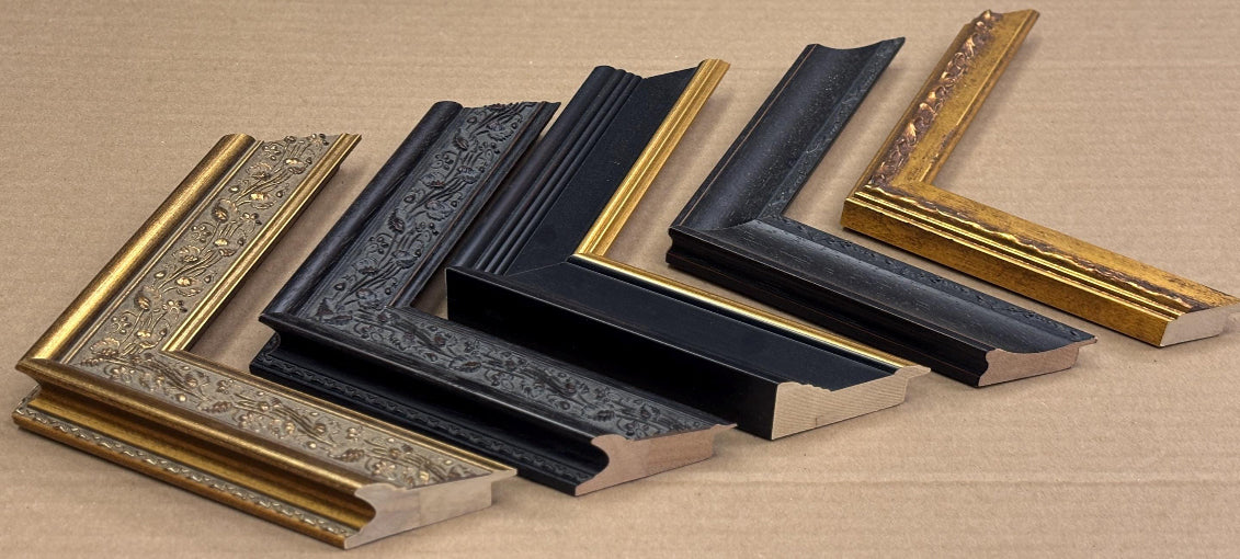 a collection of six ornate picture frames, each with a unique design and color, arranged on a cardboard background.