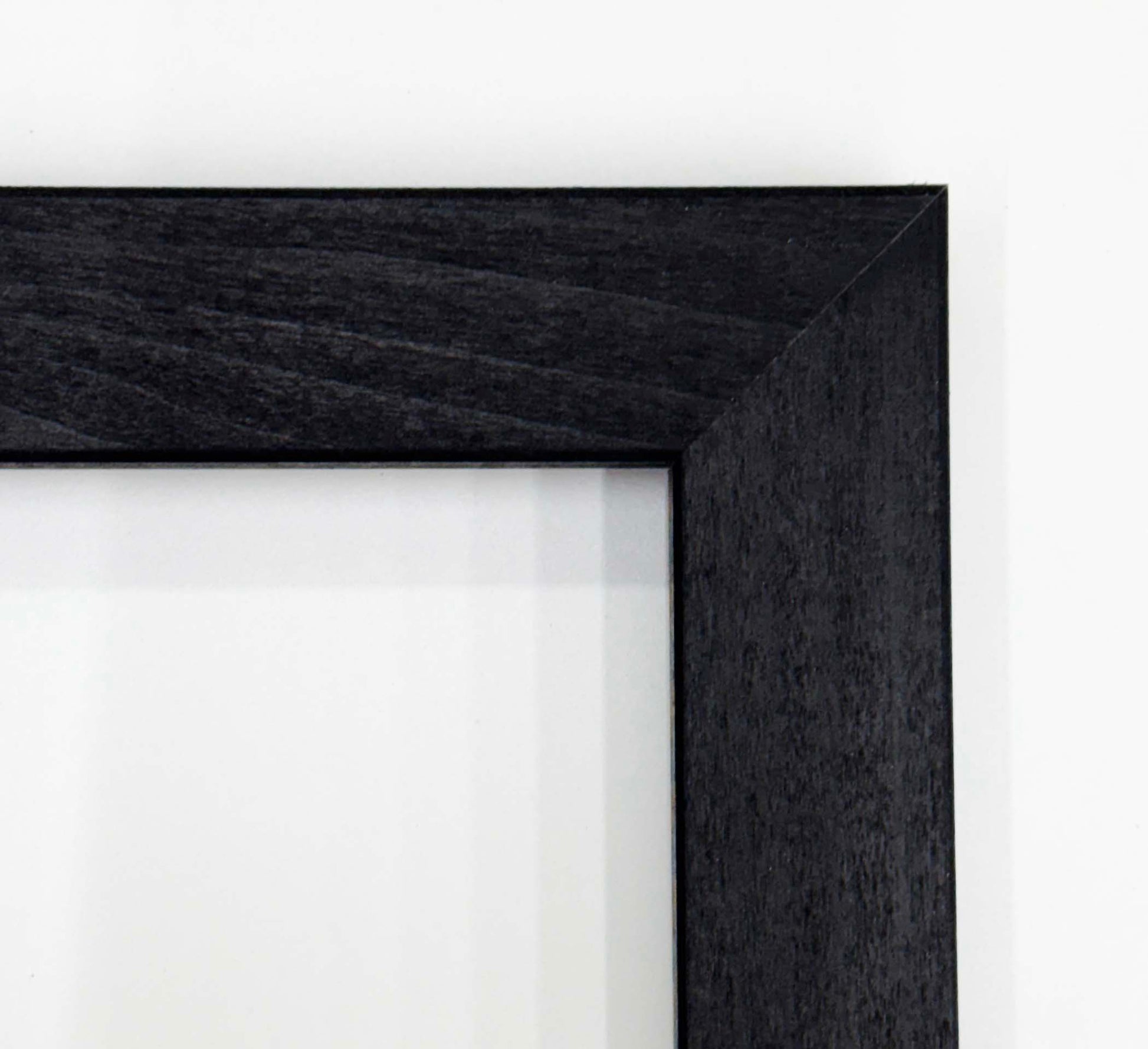 a close-up view of a black wooden frame with a dark finish, set against a white background.