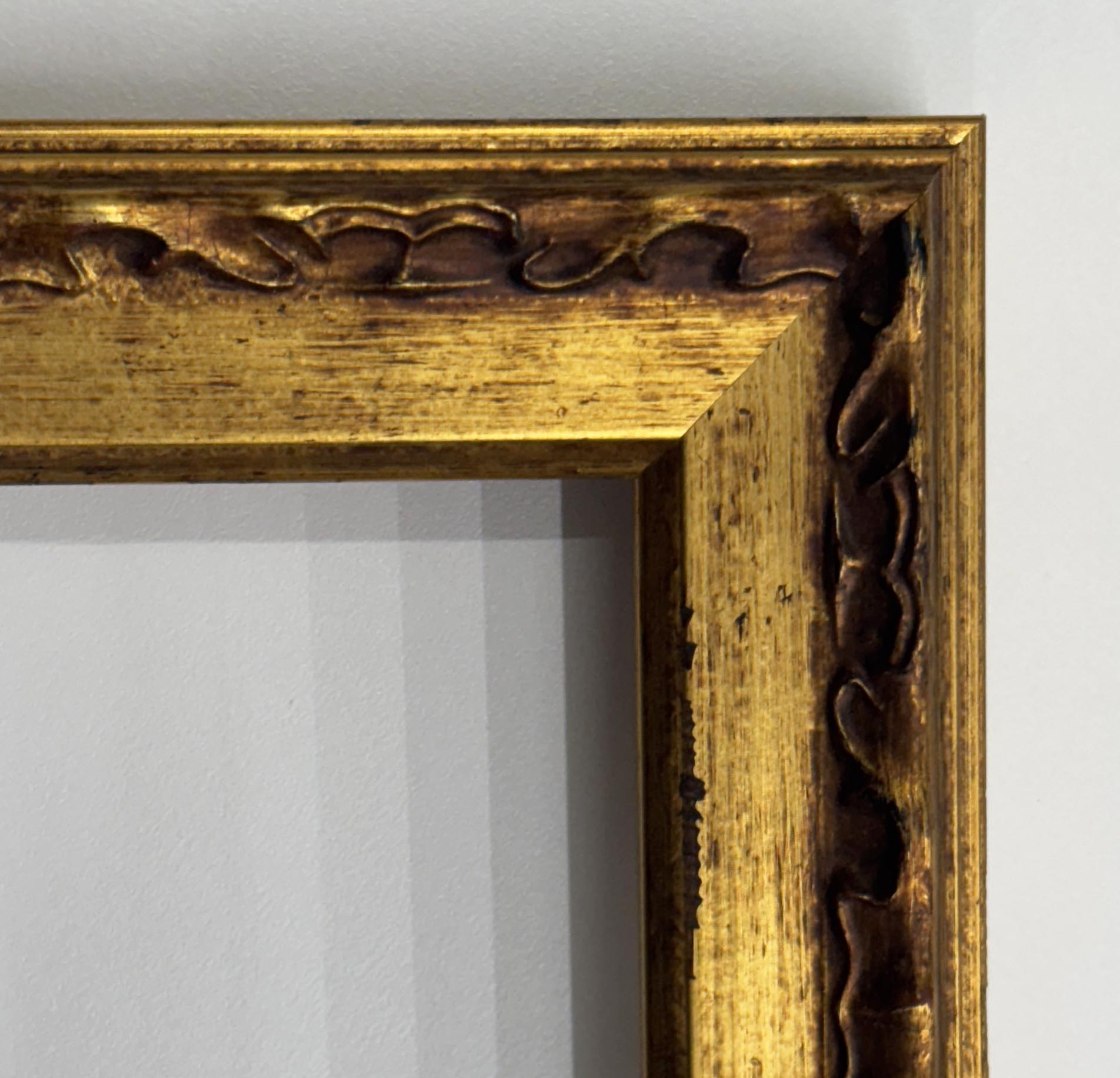 a close-up view of a gold-colored ornate frame with intricate designs on the edges.
